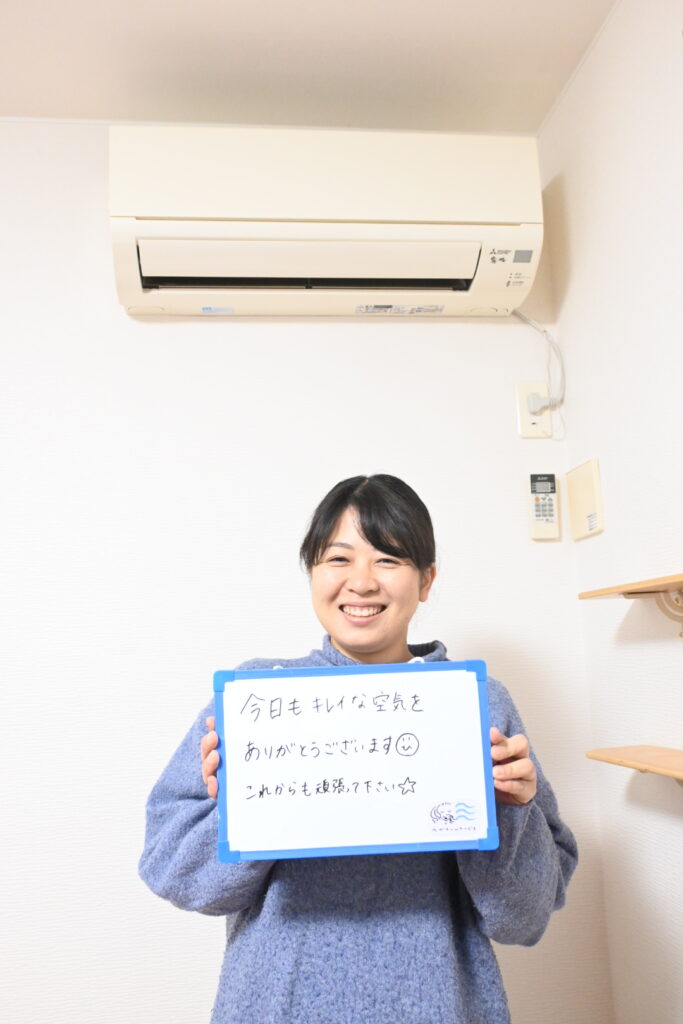 S様がホワイトボードを持って笑顔な様子