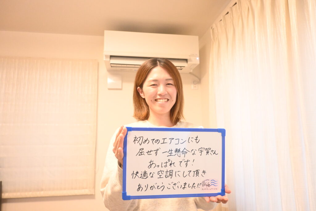 K様がホワイトボードを持って笑顔な様子