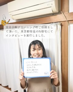 N様がホワイトボードを持って笑顔な様子