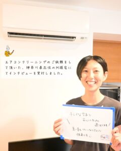 M様がホワイトボードを持って笑顔な様子
