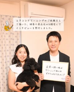 御夫婦と犬、旦那さんがホワイトボードを持っている