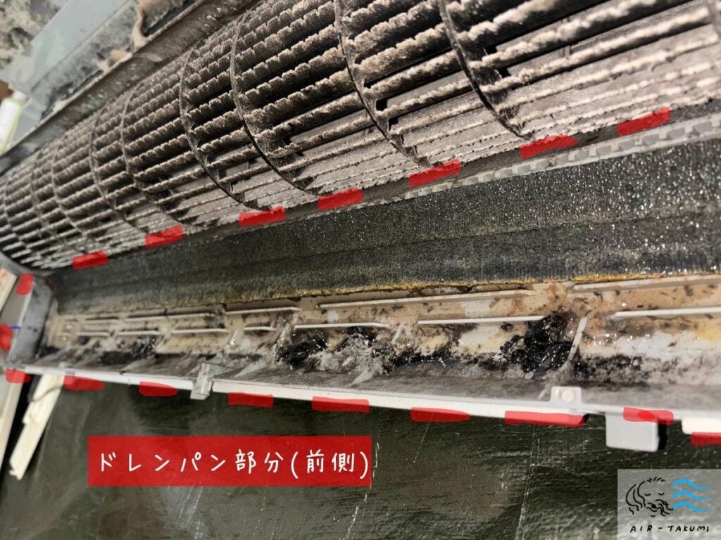 エアコンから取り外したドレンパンの前側。結露水を受け止める受け皿部分に茶色や黒色のヘドロ状汚れが堆積している