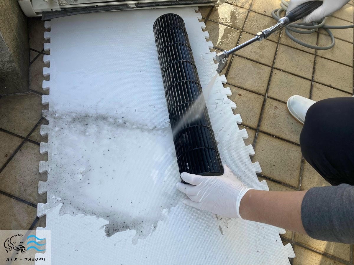 送風ファンを高圧洗浄機で洗浄している様子