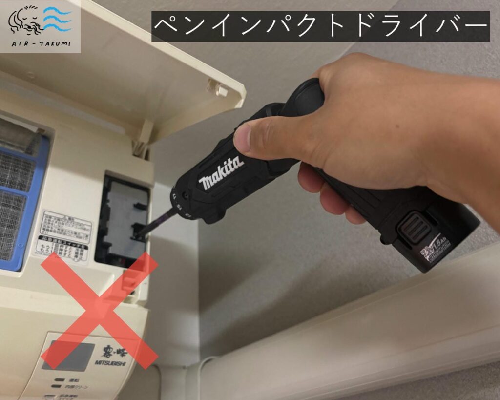 ペンインパクトドライバーでエアコンパーツを締めている写真