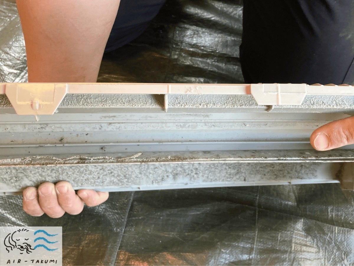 取り外したドレンパン（水の受け皿）に溜まった、カビやホコリによるヘドロ状の汚れ。