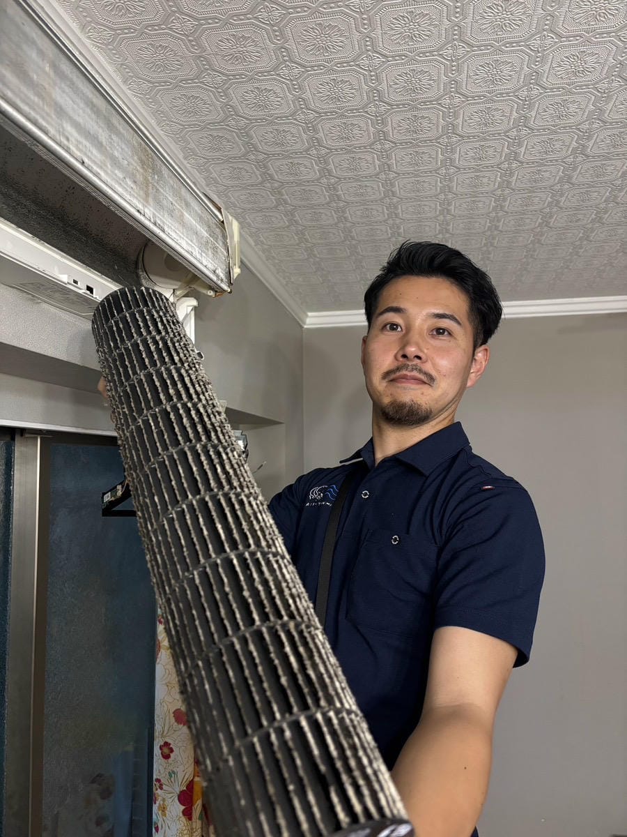 小山がエアコンのファンを取り出しお客様へ見せている様子